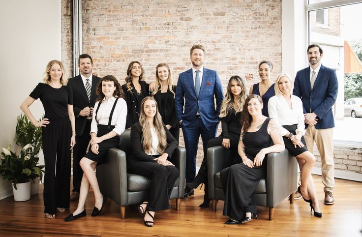Group of diverse business professionals in formal attire posing confidently in a modern office setting, corporate photography.